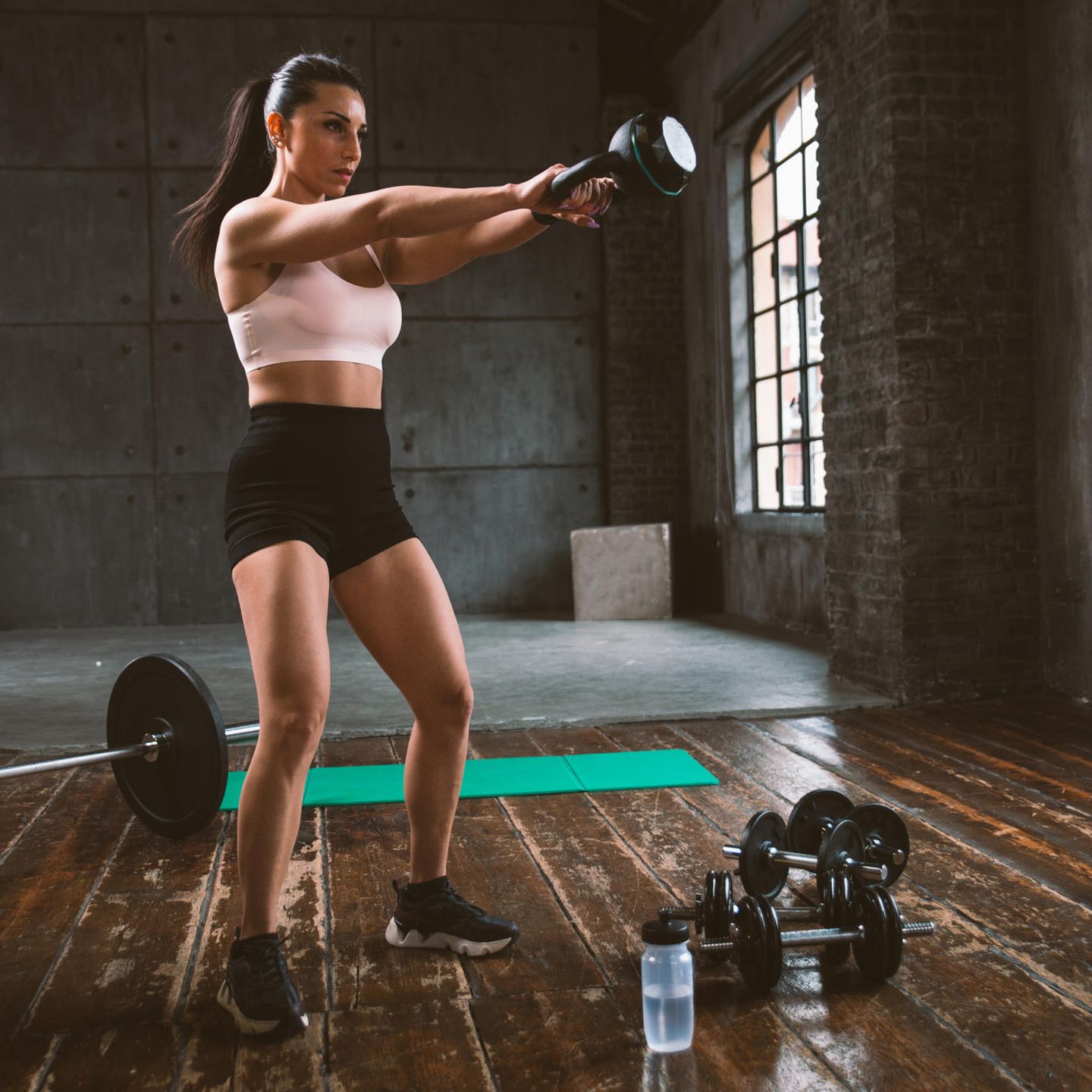 Sportarten ausprobieren: Frau beim Krafttraining mit Kettlebell