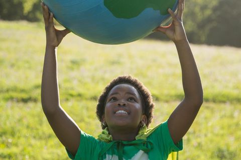 Eine Fremdsprache zu lernen finden die meisten Kinder gut – ein junges Mädchen mit einem Weltkugel-Ball