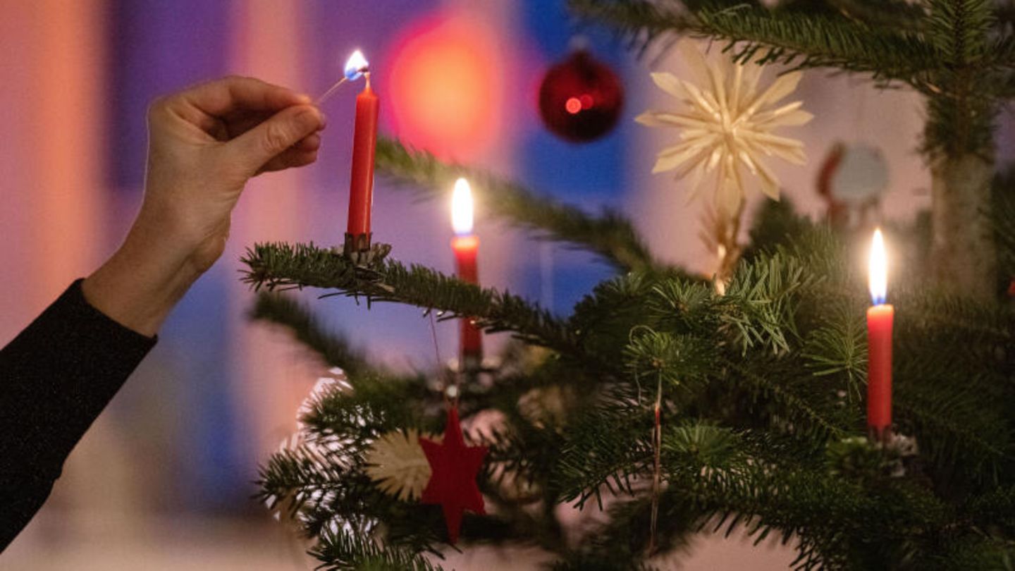 Kerzen an einem Weihnachtsbaum werden entzündet