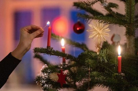 Kerzen an einem Weihnachtsbaum werden entzündet