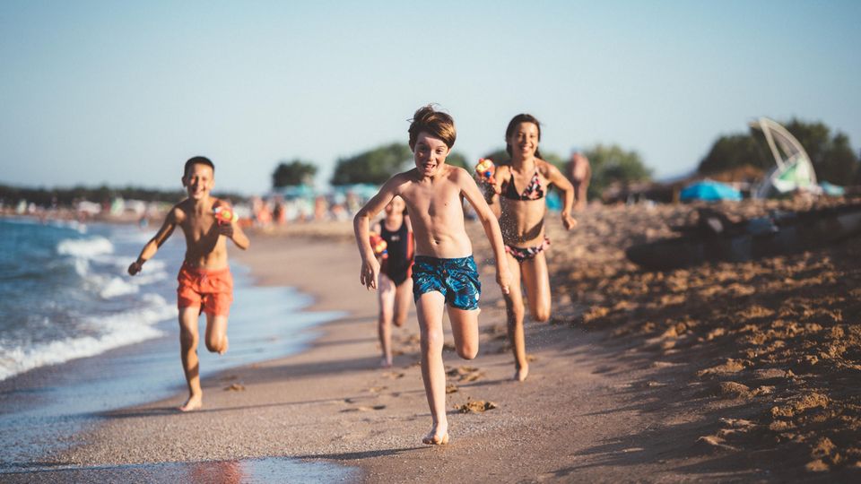 Kinder rennen am Sandstrand in Italien