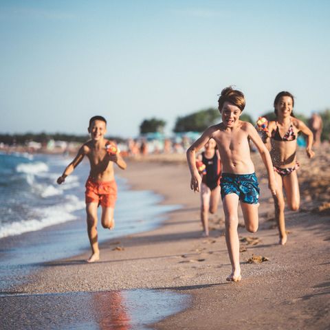 Kinder rennen am Sandstrand in Italien