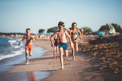 Kinder rennen am Sandstrand in Italien