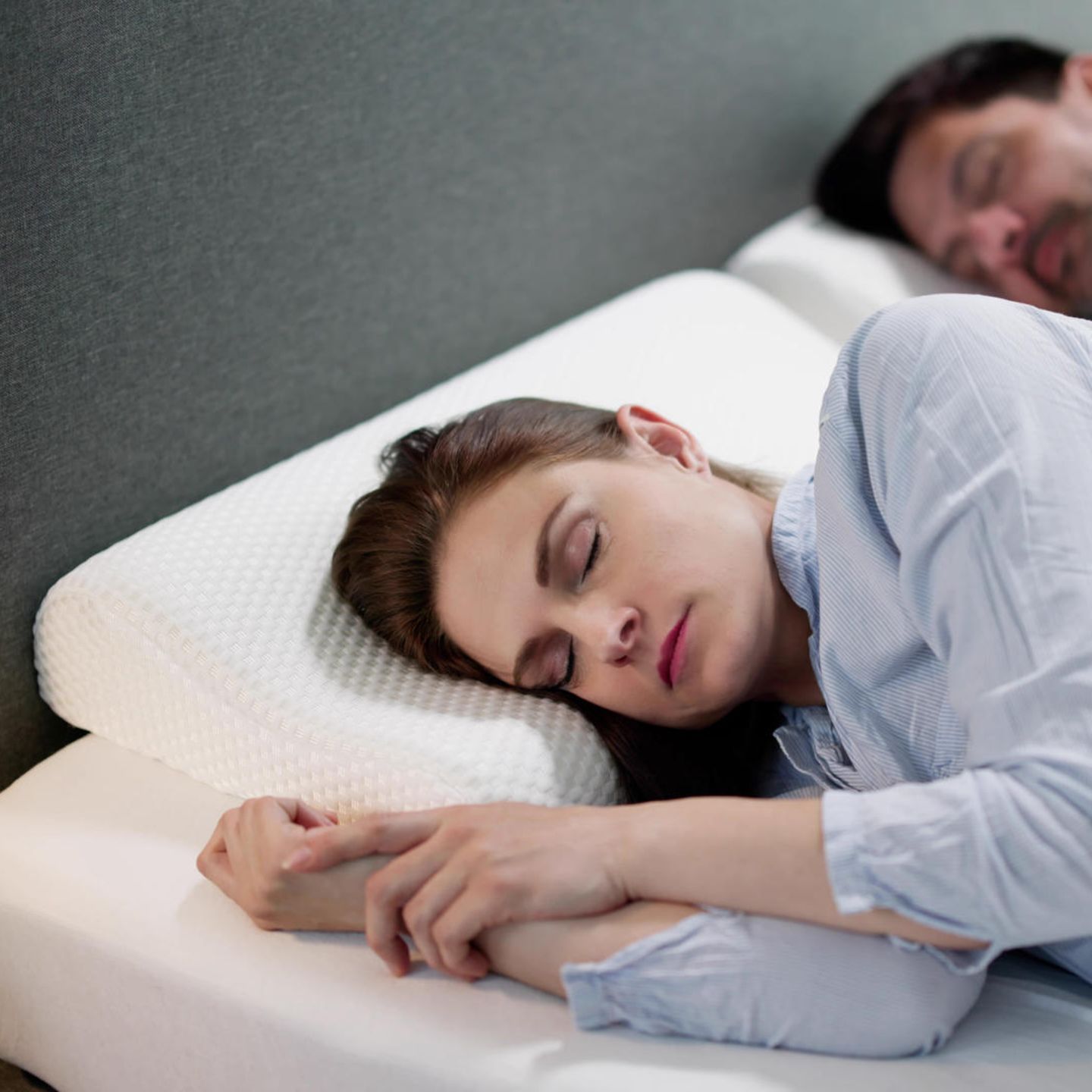 Mann und Frau schlafen auf orthopädischen Kissen