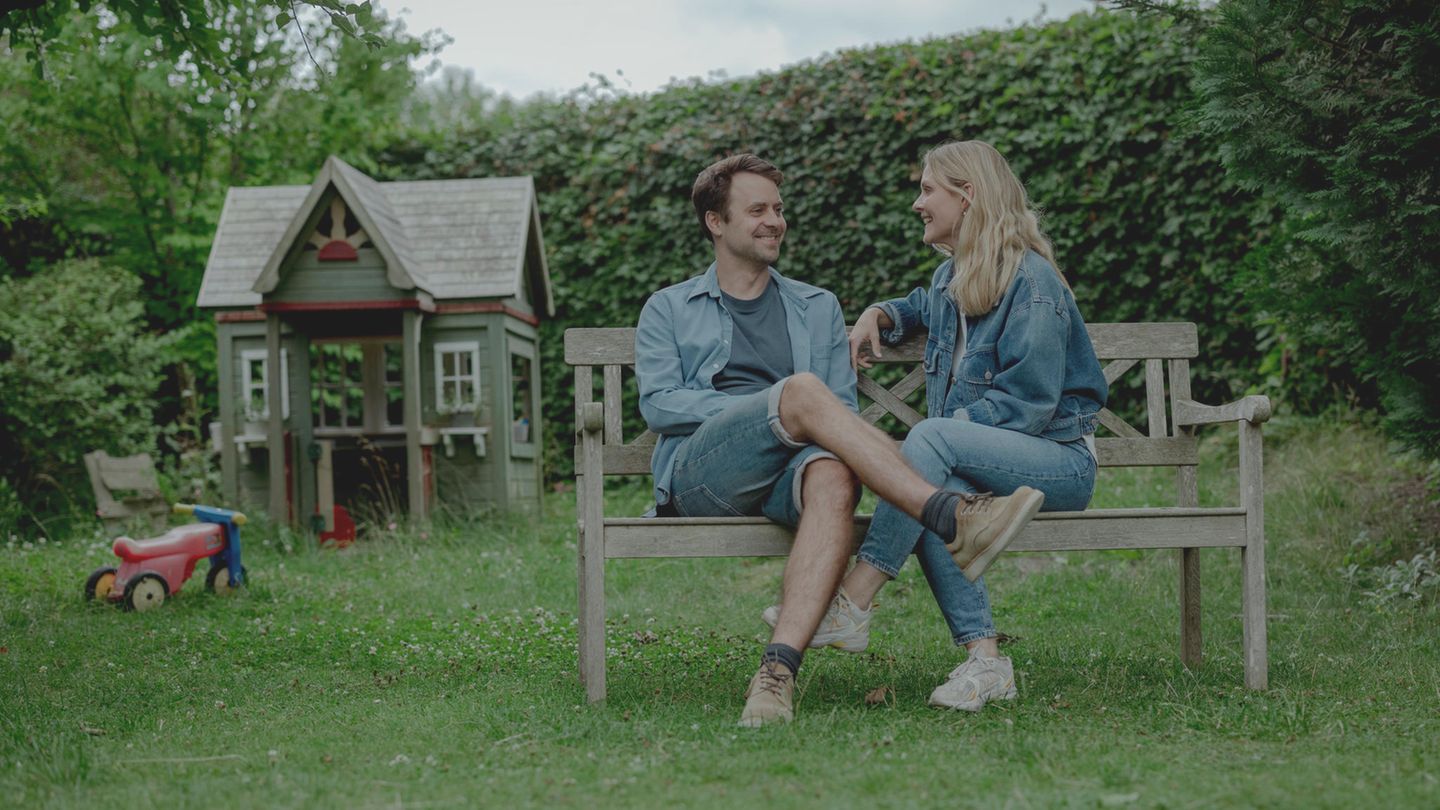 Laura Kverneland und ihr Mann Anders Handrup Kverneland sitzen auf einer Holzbank.