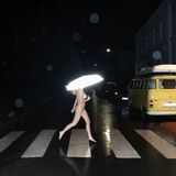 Eine Frau läuft nackt über einen Zebrastreifen