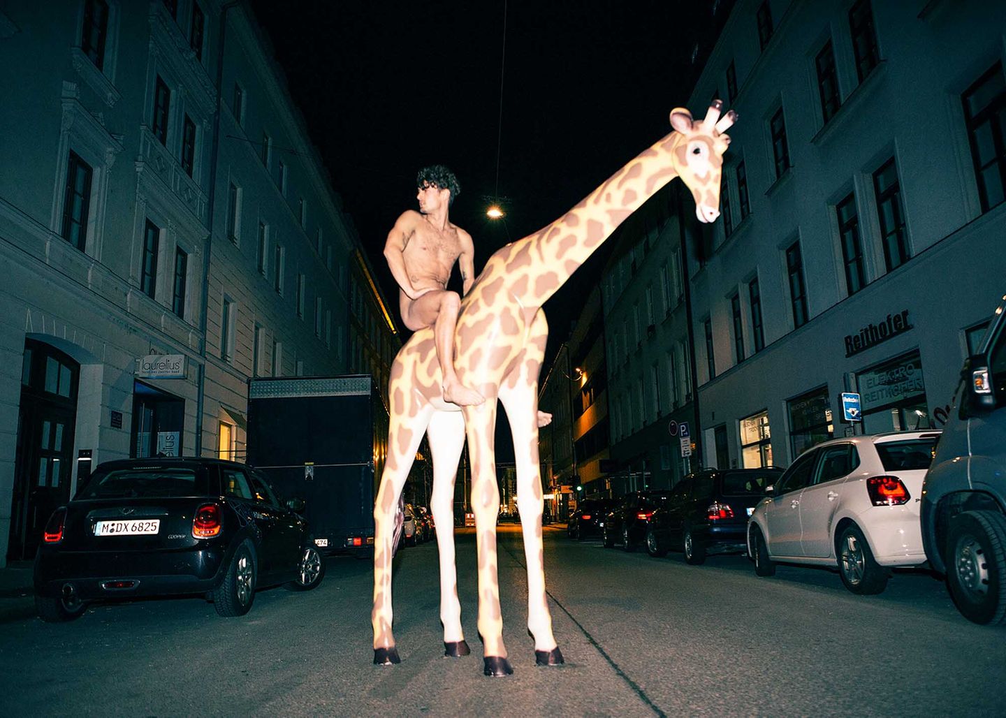 Nackter Simon Lohmeyer auf Plastikgiraffe