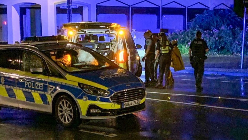 Am späten Abend stellt sich ein Mann (hinten verdeckt zwischen Polizisten) bei der Solinger Polizei auf offener Straße 