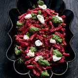 PINKE PASTA mit Dillpesto und Ricotta     In jedem Restaurant gibt es das sogenannte Mitarbeiteressen, das meist unkonventionell und schnell gemacht ist, oft zubereitet aus Resten, die noch wegmüssen. Diese Pasta ist meine Art des Resteessens, das ich für mein Team kochte, als wir die Gerichte für dieses Buch fotografierten.     Für 2 – 4 Personen  Für die Pasta  Salz  250 g Casarecce-Pasta  1 Schalotte  1 Knoblauchzehe  2 Rote-Bete-Knollen  2 EL natives Olivenöl  1 Schuss Balsamicoessig Pfeffer aus der Mühle   250 g Ricotta     Für das Dillpesto  1⁄2 Bund Dill  2 EL Zitronensaft  50 g Parmesan, grob gerieben   60 g Haselnüsse  80 ml Olivenöl  Salz, Pfeffer aus der Mühle     Zuerst das Pesto zubereiten. Dafür den Dill zusammen mit dem Zitronensaft, dem grob geriebenen Parmesan sowie den Haselnüssen in einen Mixer geben. Fein zerkleinern und das Olivenöl zugießen, bis eine cremige Paste entstanden ist. Mit Salz und Pfeffer abschmecken. In ein kleines Glas füllen, mit Olivenöl bedecken und beiseitestellen.  Dann in einem Topf ausreichend Wasser für die Pasta zum Kochen bringen. Sobald das Wasser kocht, großzügig salzen. Die Pasta-Formel lautet: 10 g Salz auf 1 Liter Wasser, damit die Sauce später nicht geschmacklich abflacht. Die Pasta etwa 10 Minuten kochen, bis sie bissfest ist.  Währenddessen die Schalotte und den Knoblauch fein würfeln. Die Rote Bete schälen und mit einer Küchenreibe fein raspeln. Am besten Handschuhe verwenden, da Rote Bete stark färbt.  In einer großen Pfanne das Olivenöl auf mittlerer Hitze erwärmen und darin die Rote Bete, die Schalotte und den Knoblauch etwa 10 Minuten dünsten. Mit dem Balsamico ablöschen. Salzen und pfeffern.  Die Hälfte des Ricotta unter die Rote Bete mischen. Die Nudeln hinzufügen und mit etwas Pastawasser zu einer sämigen Sauce rühren. Mit Salz und Pfeffer abschmecken.  Zum Schluss den restlichen Ricotta auf der Pasta verteilen und die Pasta mit dem Dillpesto garnieren. Heiß servieren.