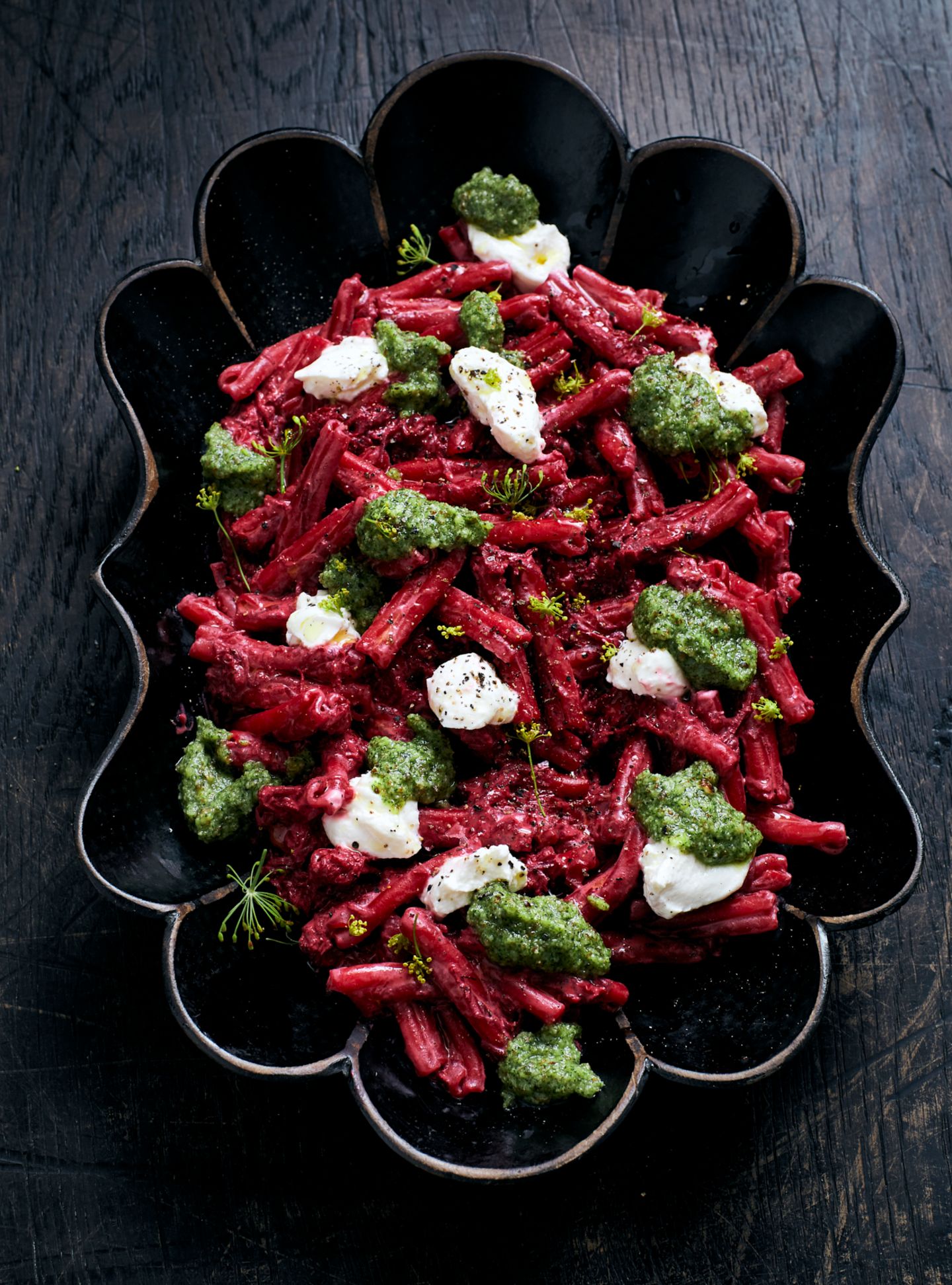 PINKE PASTA mit Dillpesto und Ricotta     In jedem Restaurant gibt es das sogenannte Mitarbeiteressen, das meist unkonventionell und schnell gemacht ist, oft zubereitet aus Resten, die noch wegmüssen. Diese Pasta ist meine Art des Resteessens, das ich für mein Team kochte, als wir die Gerichte für dieses Buch fotografierten.     Für 2 – 4 Personen  Für die Pasta  Salz  250 g Casarecce-Pasta  1 Schalotte  1 Knoblauchzehe  2 Rote-Bete-Knollen  2 EL natives Olivenöl  1 Schuss Balsamicoessig Pfeffer aus der Mühle   250 g Ricotta     Für das Dillpesto  1⁄2 Bund Dill  2 EL Zitronensaft  50 g Parmesan, grob gerieben   60 g Haselnüsse  80 ml Olivenöl  Salz, Pfeffer aus der Mühle     Zuerst das Pesto zubereiten. Dafür den Dill zusammen mit dem Zitronensaft, dem grob geriebenen Parmesan sowie den Haselnüssen in einen Mixer geben. Fein zerkleinern und das Olivenöl zugießen, bis eine cremige Paste entstanden ist. Mit Salz und Pfeffer abschmecken. In ein kleines Glas füllen, mit Olivenöl bedecken und beiseitestellen.  Dann in einem Topf ausreichend Wasser für die Pasta zum Kochen bringen. Sobald das Wasser kocht, großzügig salzen. Die Pasta-Formel lautet: 10 g Salz auf 1 Liter Wasser, damit die Sauce später nicht geschmacklich abflacht. Die Pasta etwa 10 Minuten kochen, bis sie bissfest ist.  Währenddessen die Schalotte und den Knoblauch fein würfeln. Die Rote Bete schälen und mit einer Küchenreibe fein raspeln. Am besten Handschuhe verwenden, da Rote Bete stark färbt.  In einer großen Pfanne das Olivenöl auf mittlerer Hitze erwärmen und darin die Rote Bete, die Schalotte und den Knoblauch etwa 10 Minuten dünsten. Mit dem Balsamico ablöschen. Salzen und pfeffern.  Die Hälfte des Ricotta unter die Rote Bete mischen. Die Nudeln hinzufügen und mit etwas Pastawasser zu einer sämigen Sauce rühren. Mit Salz und Pfeffer abschmecken.  Zum Schluss den restlichen Ricotta auf der Pasta verteilen und die Pasta mit dem Dillpesto garnieren. Heiß servieren.