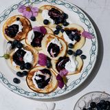 VARŠKĖS BLYNELIAI (Quarkpfannkuchen)     Wenn wir zu Besuch bei meiner Bobutė waren, backte sie immer kleine, runde Quarkpfannkuchen. Der Duft kroch schon morgens durch den Spalt unserer Zimmertür. Da wussten wir, dass es Zeit war, aufzustehen. Die selbst gemachte Heidelbeermarmelade stand schon bereit. Die Beeren hatten wir am Tag zuvor im Wald gesammelt. Mit der Marmelade und einem Klecks Sauerrahm verhilft man den Pfannkuchen zur Perfektion.     Für 4 Personen  2 Eier  250 g Quark (mind. 40 % Fett)  20 g brauner Zucker  1 Prise Salz  120 ml Milch  100 g Weizenmehl (Type 550)  1 1⁄2 EL Butterschmalz oder Speiseöl zum Braten     Die Eier trennen. Die Eigelbe mit dem Quark, dem Zucker und dem Salz vermengen. Die Milch dazugeben und alles mit einem Schneebesen verquirlen. Das Mehl sieben, hinzufügen und alles gründlich verrühren.  Das Eiweiß in der Küchenmaschine oder mit dem Handrührgerät steif schlagen und vorsichtig unter den Teig heben.  In einer Pfanne das Butterschmalz oder Speise- öl erhitzen. Vom Teig mit einem Esslöffel kleine Portionen abnehmen, in das erhitzte Fett geben und zu Pfannkuchen formen. Wenige Minuten von beiden Seiten braten, bis die Pfannkuchen goldbraun sind. Dazu schmecken Heidelbeermarmelade und saure Sahne (Sauerrahm).