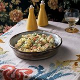 BALTA MIŠRAINĖ (weißer Kartoffelsalat)     Balta Mišrainė, also der weiße Kartoffelsalat, ist in Litauen eine Art Nationalsalat. Wenn an Festtagen alle gemeinsam am Tisch sitzen, kommt man an diesem geschmackvollen Kartoffelsalat nicht vorbei. Ich liebe ihn und kann ihn zu jeder Tageszeit essen. Er schmeckt besonders gut zu gegrilltem Fleisch oder auch Fisch.     Für 4 Personen   500 g vorwiegend festkochende Kartoffeln  4 Eier  200 g Essiggurken  1 große Dose Erbsen & Karotten (530 g)   200 g saure Sahne (Sauerrahm) oder Mayonnaise (ich mache auch gern halb-halb)   1 Schuss Gurkensud nach Belieben  1 EL mittelscharfer Senf   Salz, Pfeffer aus der Mühle   2 EL frisch gehackter Dill     Die Kartoffeln mit Schale in kochendem Wasser garen, dann abgießen, erkalten lassen, schälen und in Würfel schneiden.  Die Eier etwa 8 Minuten hart kochen, abkühlen lassen, schälen und ebenfalls in Würfel schneiden.  Die Essiggurken würfeln. Die Erbsen und Karotten abschütten, die Karotten klein schneiden, und beides in eine große Schüssel geben. Die Kartoffeln, Eier und Essiggurken dazugeben und alles mit der sauren Sahne oder der Mayonnaise vermengen. Für etwas mehr Säure einen Schuss Gurkensud dazugeben. Mit dem Senf sowie Salz und Pfeffer abschmecken und den Dill unterheben. Bis zum Servieren kühl stellen. Der Salat schmeckt sehr gut als Vorspeise oder als Beilage zu Grillfleisch.