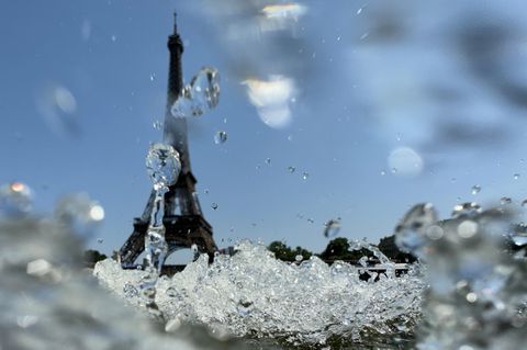 Eine Welle schwappt vor Eiffelturm-Kulisse durch die Seine