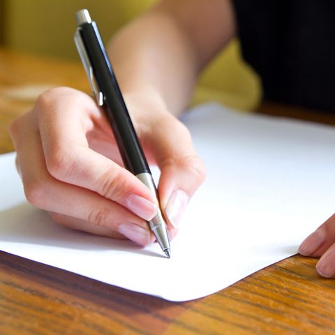 Nahaufnahme einer Hand mit Stift, die einen Brief schreibt