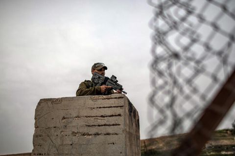Ein bewaffneter israelischer Soldat hält auf seinem Posten Wache