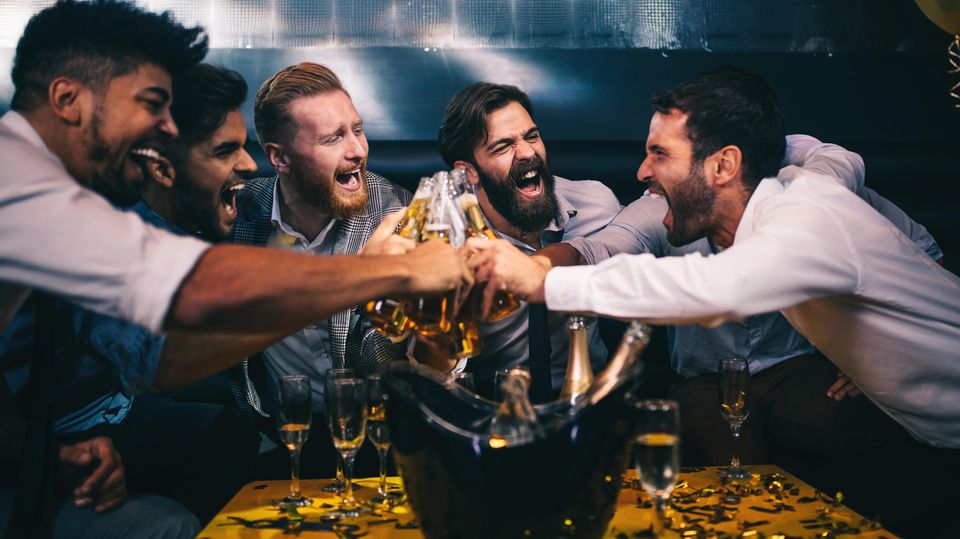 Leuke mannen stoßen mit Champagner an