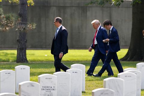 Donald Trump geht mit Begleitern über den Friedhof Arlington