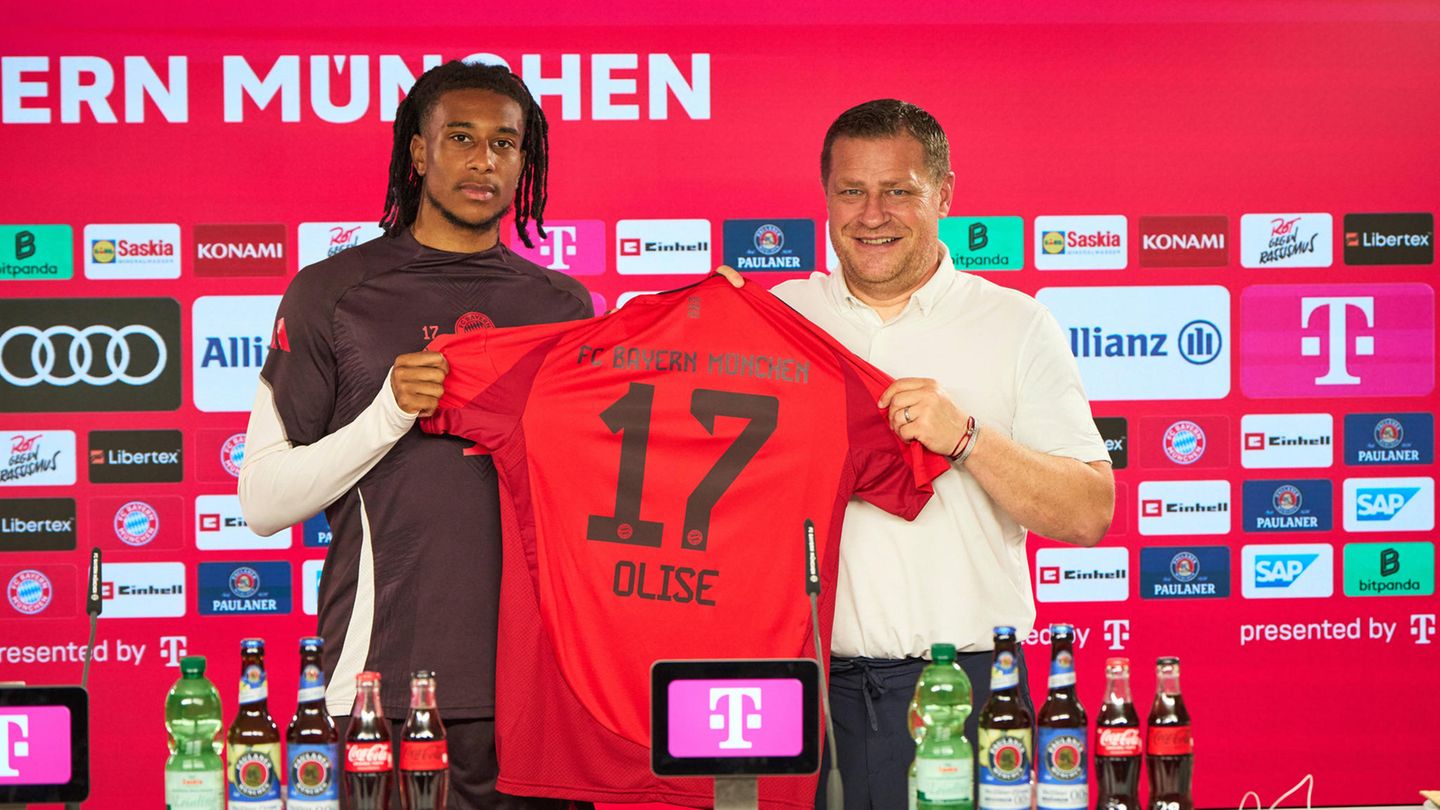 Michael Olise – 53 Millionen Euro Michael Olise und Max Eberl mit dem Bayern-Trikot des Franzosen