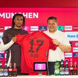 Michael Olise und Max Eberl mit dem Bayern-Trikot des Franzosen