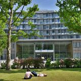 zwei Menschen liegen auf der Wiese des Charité Krankenhauses Benjamin Franklin, Berlin