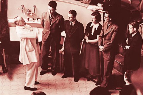 Professor Ferdinand Sauerbruch unterhält sich mit Medizinstudenten im Hörsaal der Charite