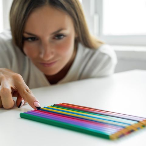 Eine Frau ordnet exakt ihre Stifte an, sie leidet wohlmöglich unter Perfektionismus