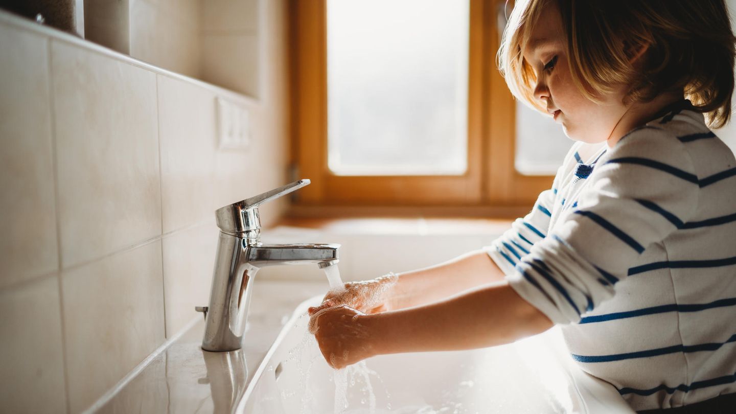 Kleines Kind im Profil wäscht sich die Hände