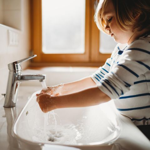 Kleines Kind im Profil wäscht sich die Hände