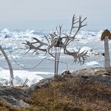 Kunstinstallation neben einem Haus: links von den Rentiergeweihen die Kieferknochen eines Wals, und rechts aus Holz vergrößerte traditionelle Werkzeuge, die zum Enthäuten von Robben genutzt werden