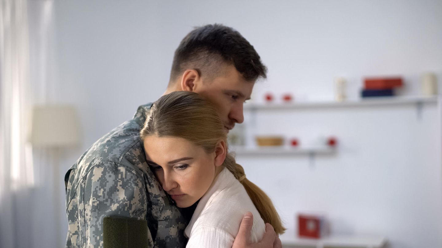 Ein Soldat und eine Frau umarmen sich