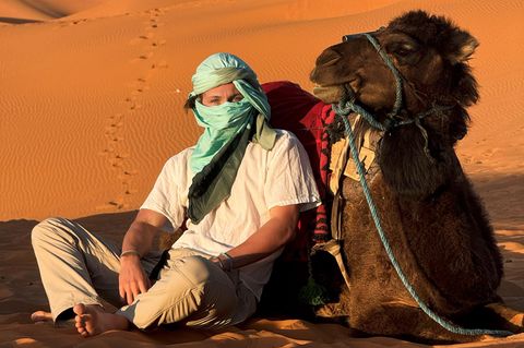 Influencer Marinus Obermair mit einem Kamel in der marokkanischen Wüste
