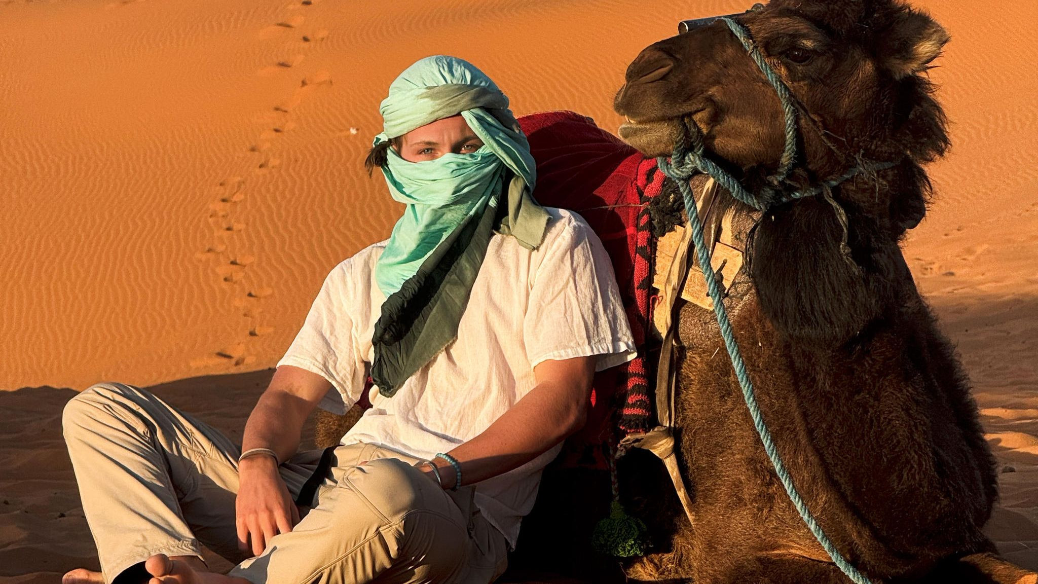 Influencer Marinus Obermair mit einem Kamel in der marokkanischen Wüste