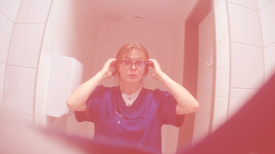 Undercover Journalistin Lisa steht im Fahrstuhl der Charité mit Berufskleidung