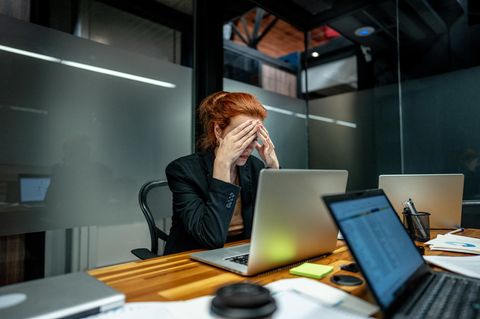 Jobhopping: Eine Frau sitzt frustriert an ihrem Arbeitsplatz