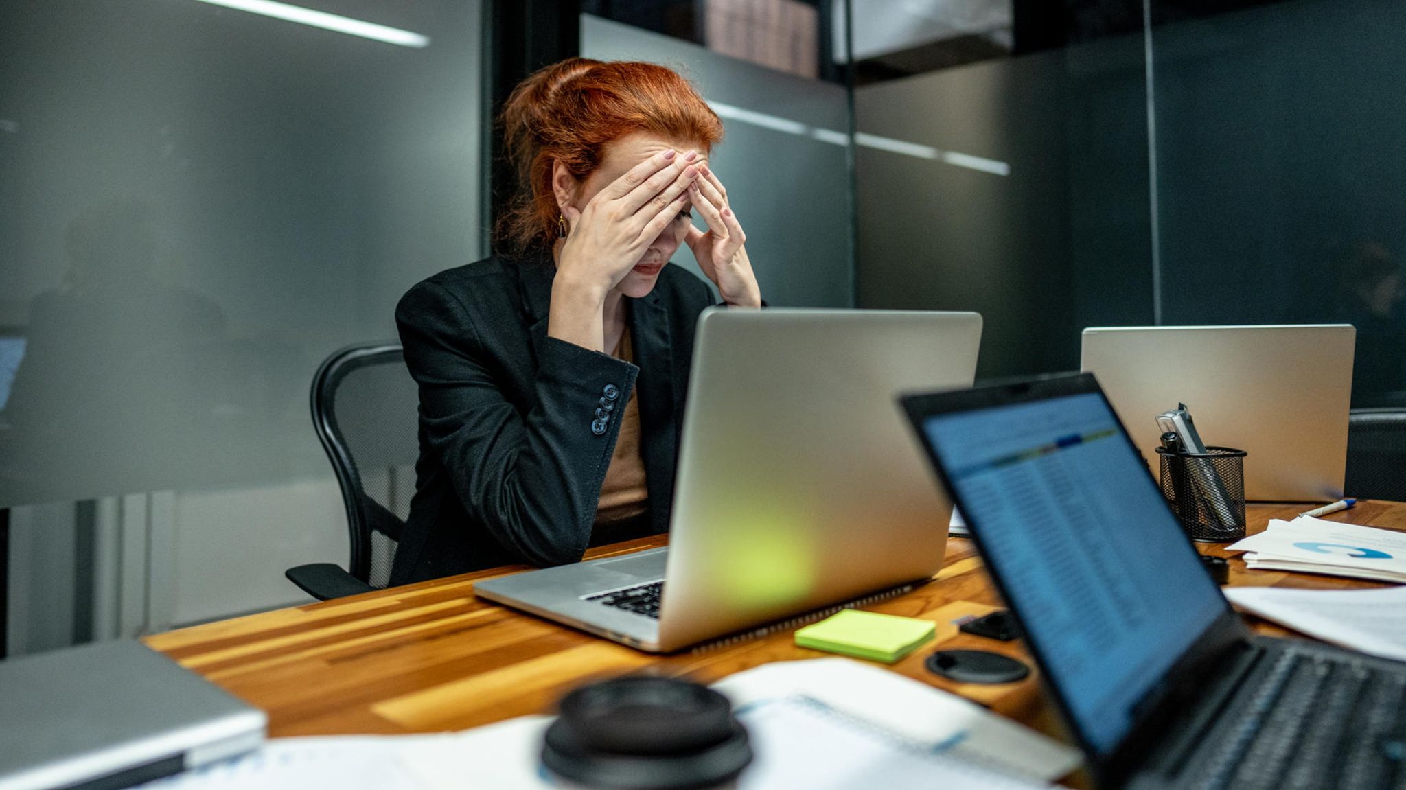 Jobhopping: Eine Frau sitzt frustriert an ihrem Arbeitsplatz