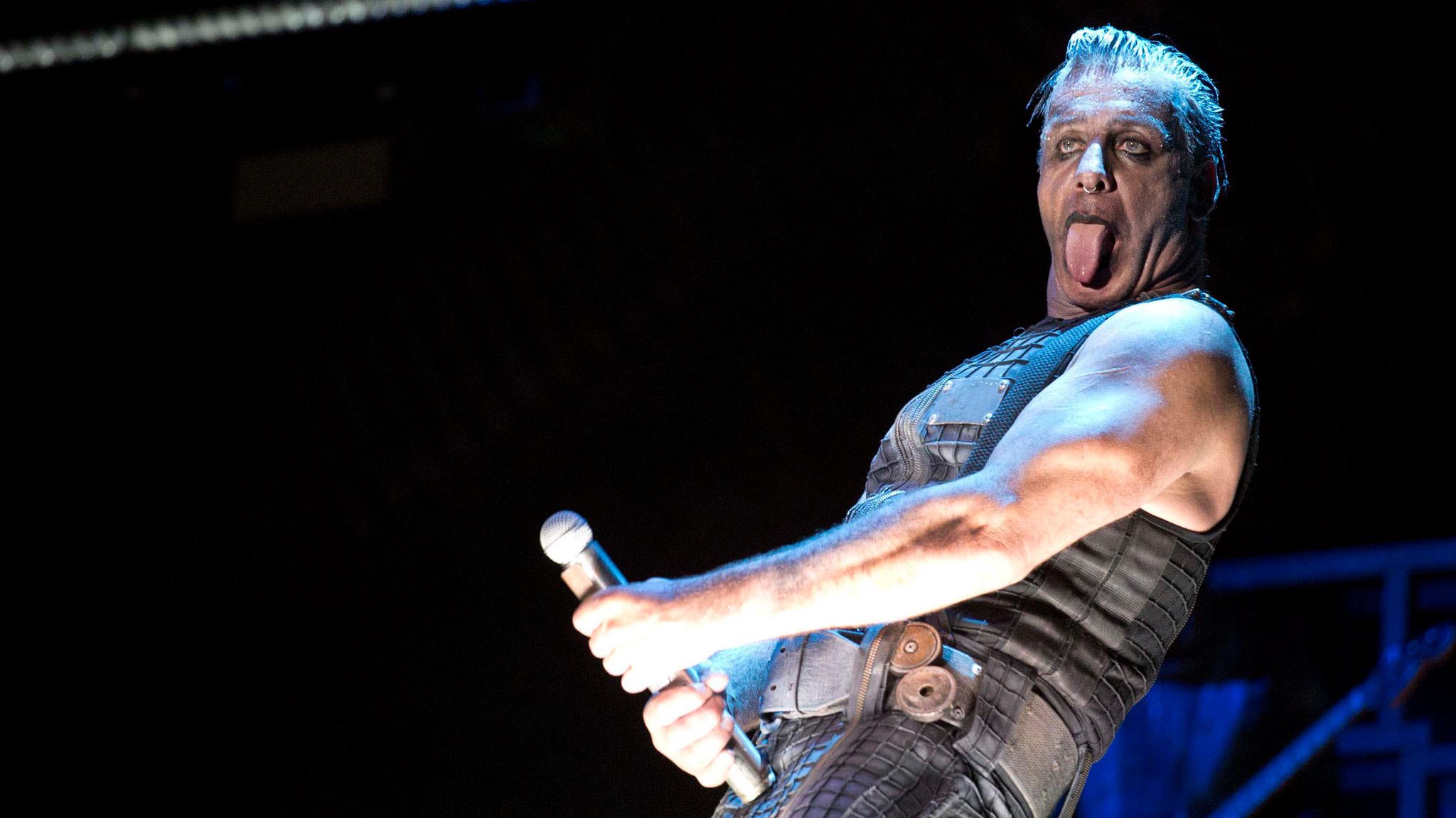 Rammstein-Frontmann Till Lindemann macht eine öbszöne Geste mit einem Mikrofon
