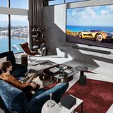 IFA 2024: Ein Mann sitzt mit seinem Hund vor einem LG Evo M4 und schaut TV