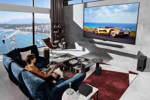 IFA 2024: Ein Mann sitzt mit seinem Hund vor einem LG Evo M4 und schaut TV