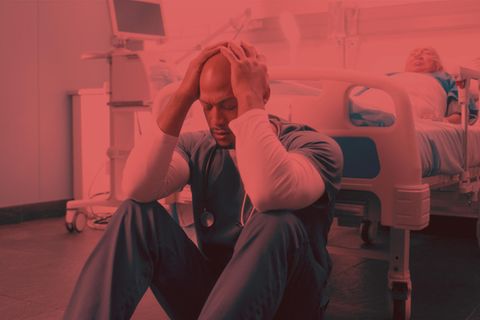 Ein Arzt sitzt verzweifelt am Bettende eines toten Patienten