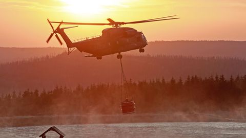 Ein Hubschrauber der Bundeswehr fliegt mit einem Wasserbehälter zum Königsberg am Brocken