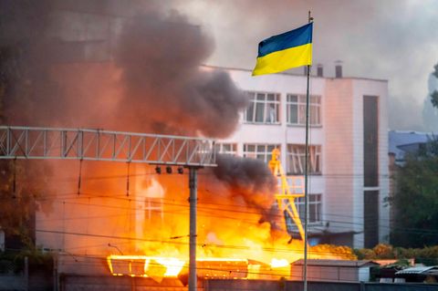 Die Flagge der Ukraine vor dichtem Rauch nach einem russischen Raketenangriffen auf Kiew