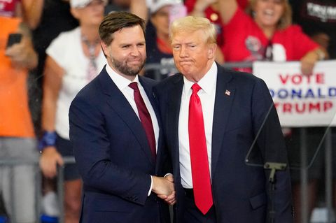 Donald Trump und J. D. Vance schütteln sich bei bei einer Wahlkampfveranstaltung die Hände