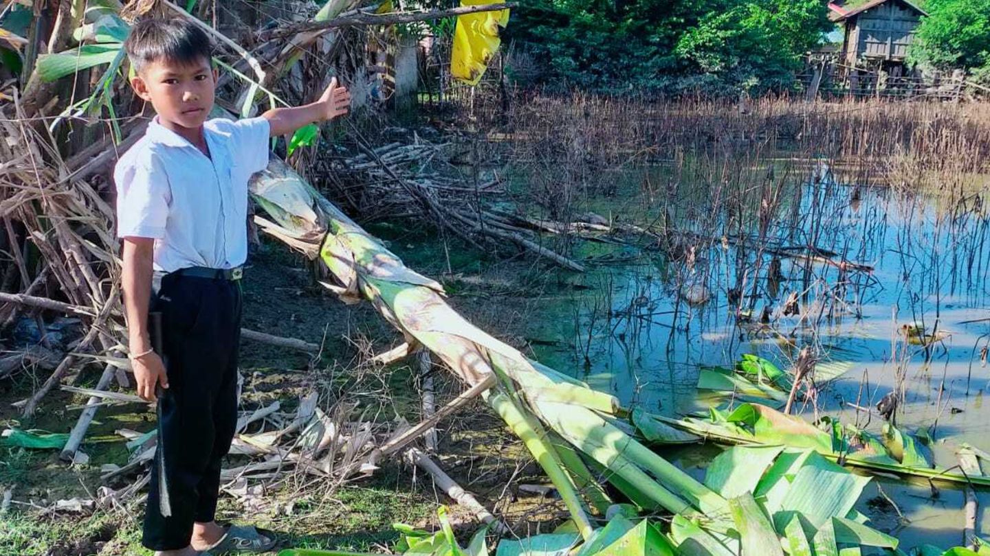 In Laos zeigt ein neunjähriger Junge die Schäden, die der Taifun in seinem Dorf hinterlassen hat