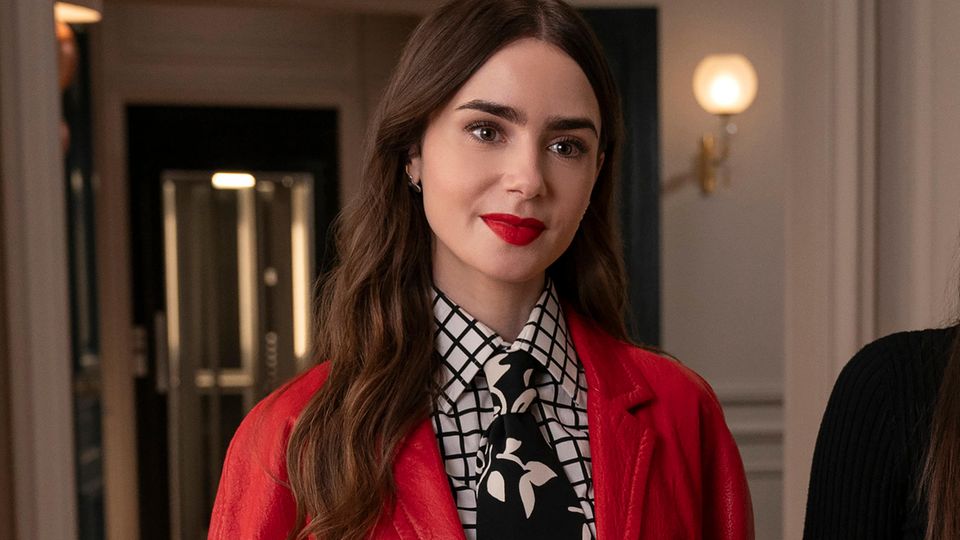 Lily Collins als Emily in einem roten Blazer