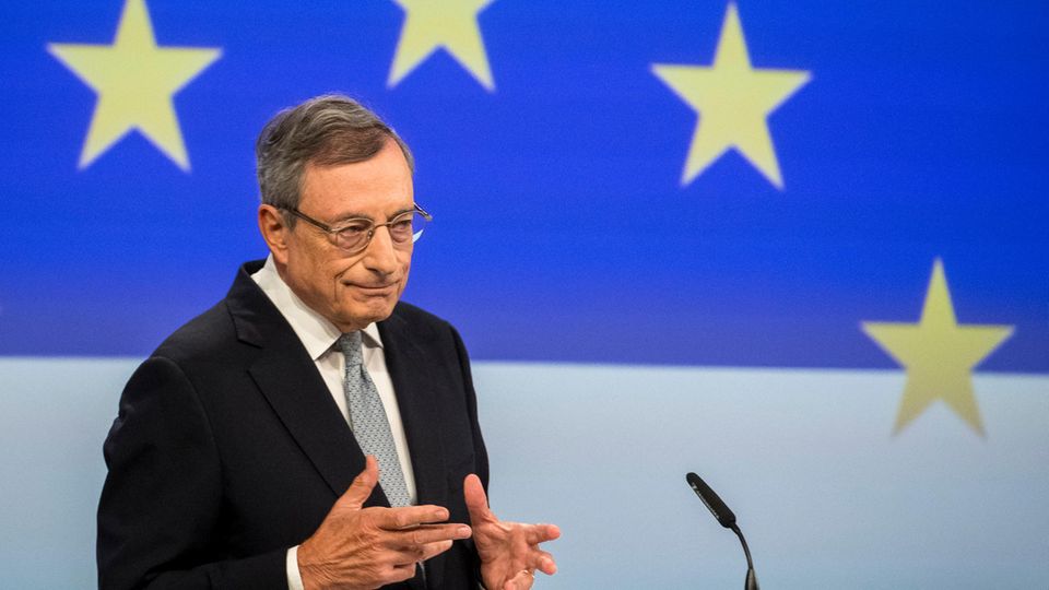 Mario Draghi steht an einem Rednerpult vor EU-Sternen