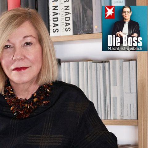 Literaturagentin Karin Graf steht vor einem großen Bücherregal mit Romanen