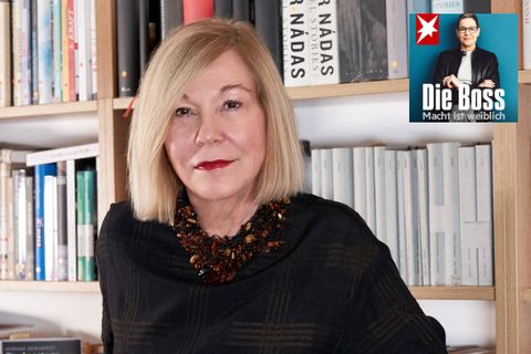 Literaturagentin Karin Graf steht vor einem großen Bücherregal mit Romanen