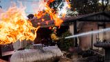 Feuerwehrmann Nolan Graham sprüht Wasser um eine verbrannte Garage, während das Boyles-Feuer in Clearlake, Kalifornien, brennt