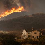 Am Lake Elsinore nähert sich das Airport Fire einem Haus. In mehreren Bezirken im Süden des Bundesstaates wurden Anwohner mittlerweile aufgefordert, sich aus der Gefahrenzone in Sicherheit zu bringen. Noch steht hier aber ein Auto vor dem Haus. Sind die Bewohner noch da – oder mit einem anderen Fahrzeug geflohen? 