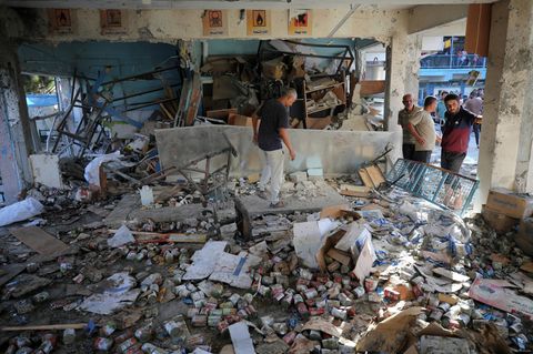 Menschen gehen durch die Trümmer in dem Schulgebäude in Gaza, das Israel angegriffen hat